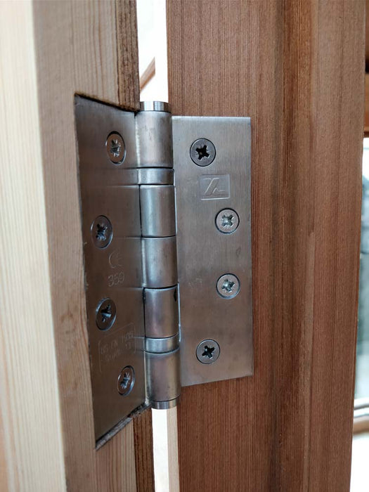 Close-up detail of a metal hinge on the door of the Alton Cedar Fusion Greenhouse. 