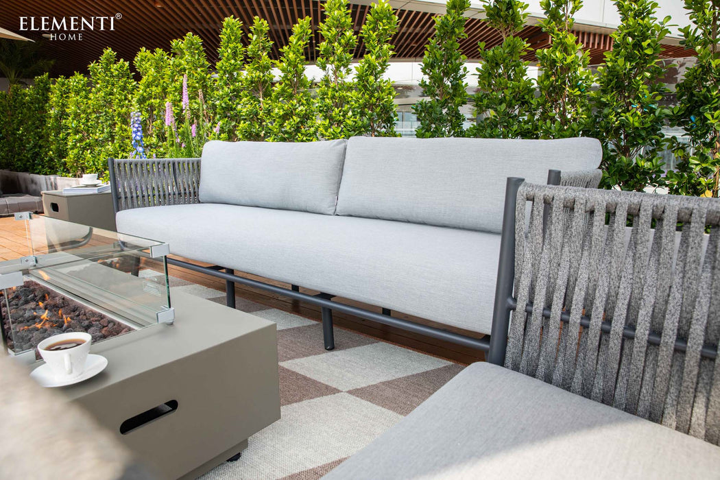 Close-up of a luxurious Elementi Milano Collection outdoor sofa, highlighting its sleek design, plush cushions, and durable grey fabric.