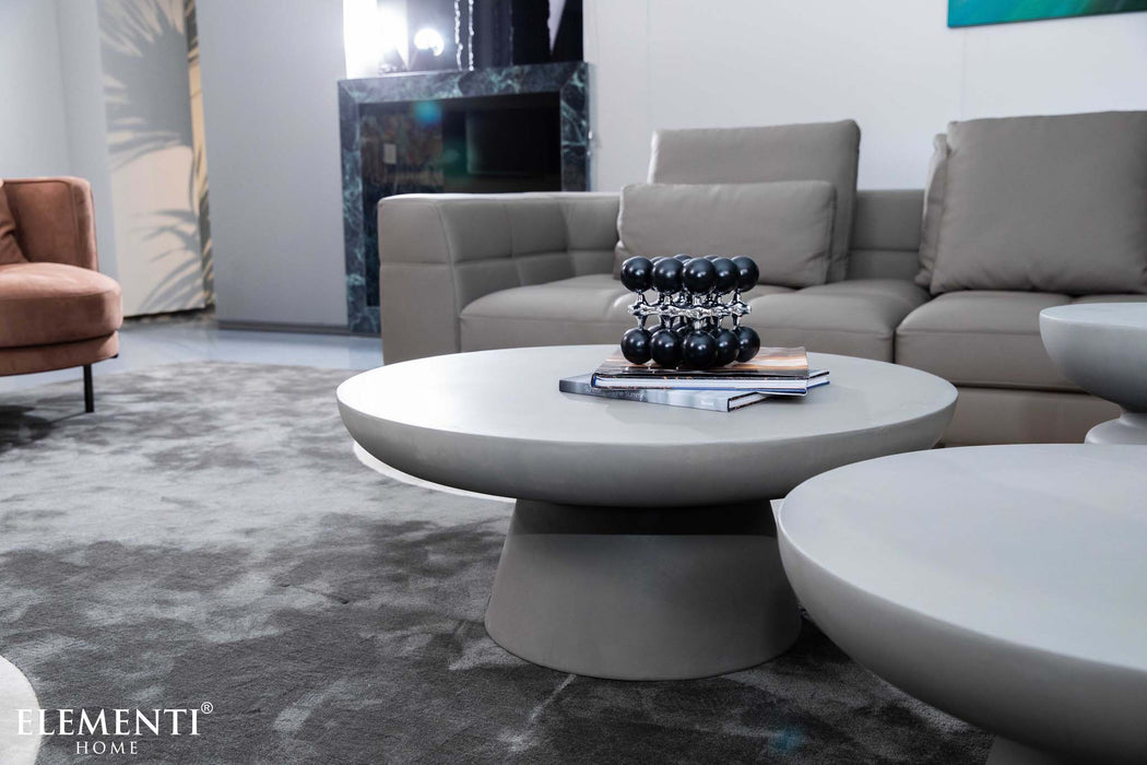 Close-up of Elementi Kylix Series medium coffee table in space grey, featuring its smooth finish and books as part of the modern living room setup.