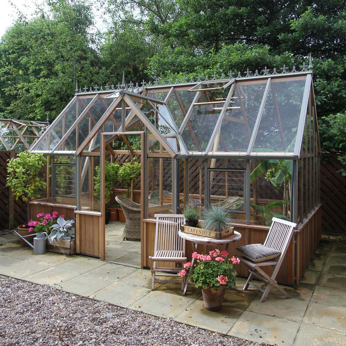 A compact yet elegant Alton Cambridge Cedar Greenhouse, perfect for a garden retreat.