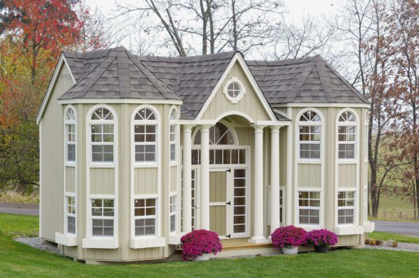 Little Cottage Company's Grand Mansion playhouse with a portico front, set against a natural landscape.