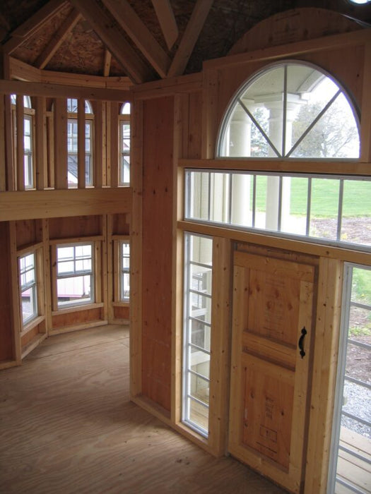 A look inside the Little Cottage Company's Grand Mansion, featuring the lofted play area and multiple windows.