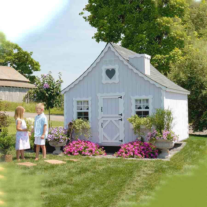 Side view of the Little Cottage Company Gingerbread Cottage Playhouse showcasing the playful pink and white color scheme.