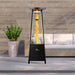 The Inferno Flame Tower Heater stands tall and lit in a daytime setting, its flame providing a striking contrast to the bright daylight