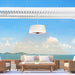 A sleek white Sol Pendant Electric Heater offers a cozy atmosphere on a beachfront patio, enhancing the modern outdoor dining experience.