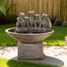 Decorative frog water fountain with stone basin and pedestal base, creating soothing ambiance in landscaped yard
