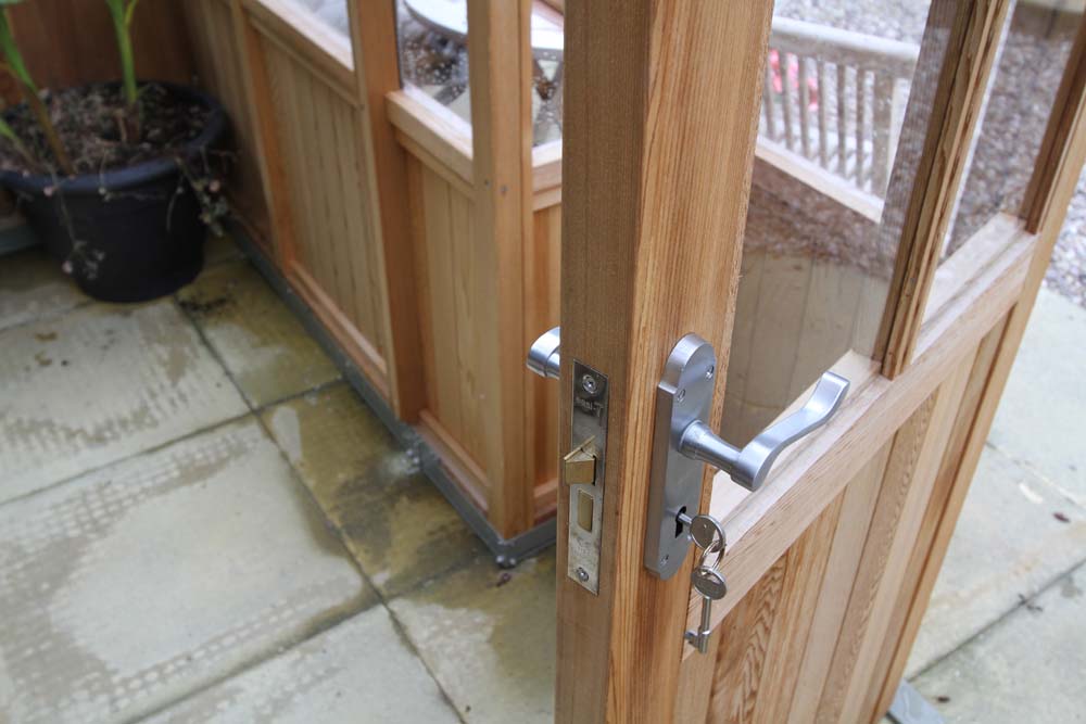 Detailed view of the door and lock system of the Alton Cambridge Cedar Greenhouse.