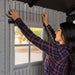 Interior view of the Lifetime storage shed's window frame with a person measuring for installation.
