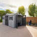 Lifetime dual entry storage shed with open side door, woman gardening in the background.