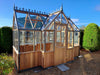 A detailed look at the door and ventilation system of the Alton Cedar Structure Durham Greenhouse 7x12, demonstrating its thoughtful features.