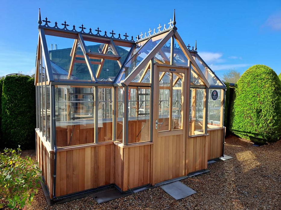 A detailed look at the door and ventilation system of the Alton Cedar Structure Durham Greenhouse 7x12, demonstrating its thoughtful features.