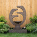 Eclipse garden water fountain centered in landscaped yard with flowering shrubs and wood fence backdrop, showcasing cascading water.