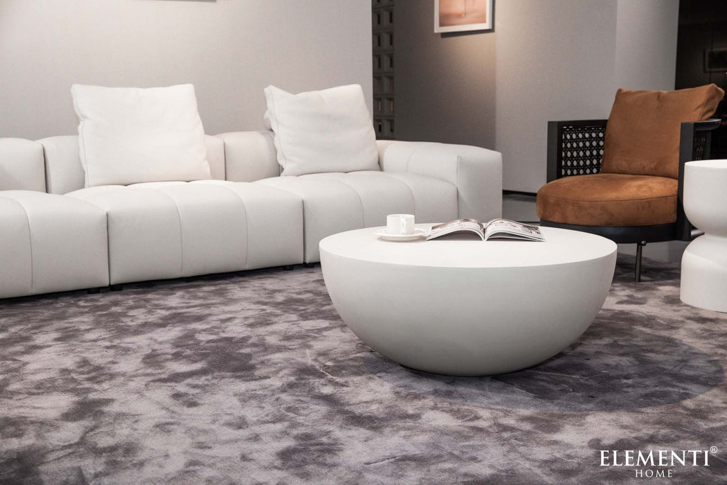 Medium-sized Elementi Chronos Series coffee table in cream white, complementing a white sofa and a cozy living room setting.