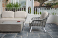 Outdoor patio setting featuring the Elementi Colorado Series Space Grey Square Large Coffee Table with 
two chairs.