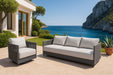 Elegant outdoor setup of the Capri Collection sofa and swivel chair by Elementi, perfectly situated on a scenic patio overlooking the ocean.
