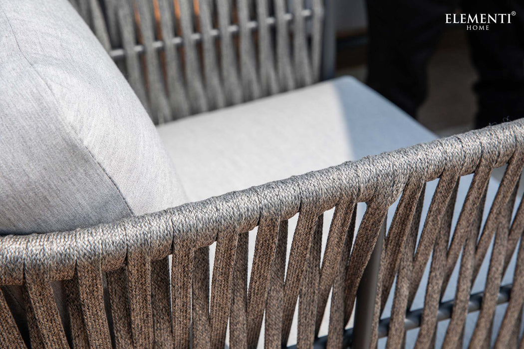 Close-up of a woven chair from the Elementi Laguna Collection. Highlights the texture and intricate design of this outdoor furniture piece.