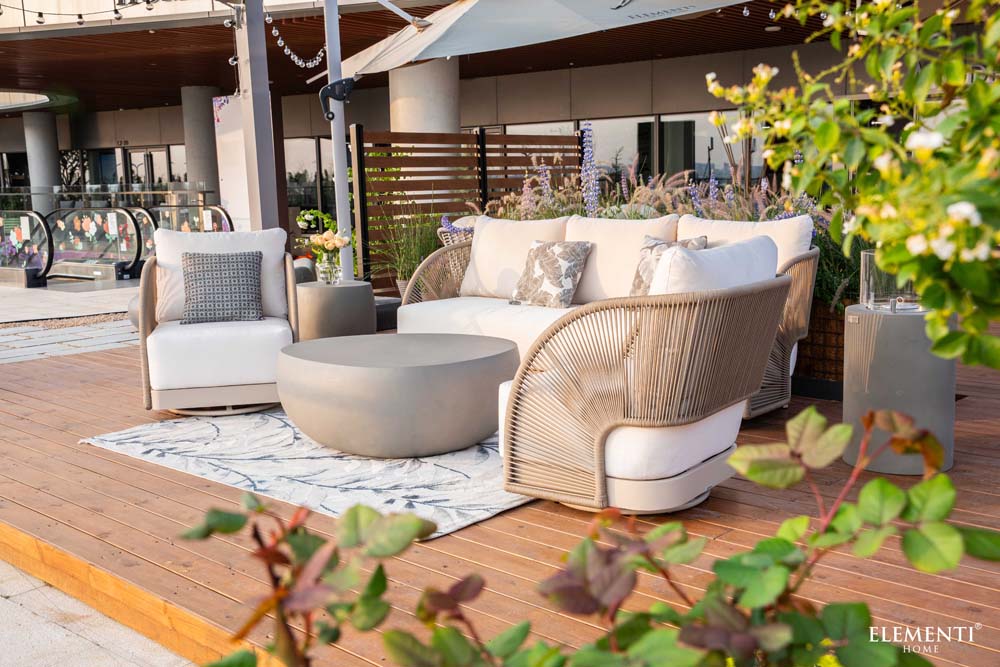 Stylish Malibu Collection lounge set by Elementi Outdoor Furnitures on a modern terrace, with curved chairs and neutral tones 