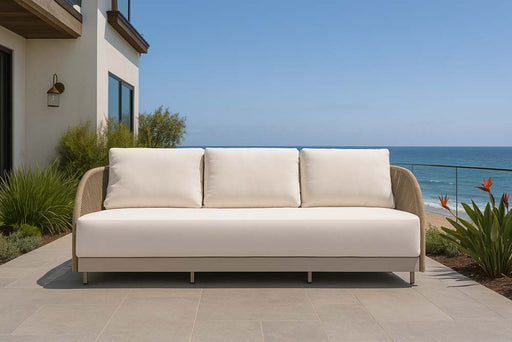 Elegant Malibu Collection sofa from Elementi on a sleek beach terrace, with neutral-tone design and contemporary lines against an ocean backdrop.
