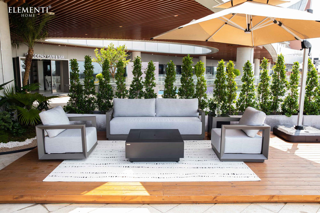 Elementi Outdoor Furnitures Newport Collection lounge set with a sofa, two armchairs, and a stylish coffee table on a wooden deck.