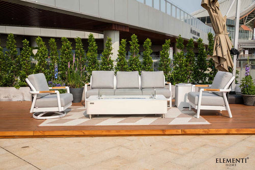 An expansive Elementi Outdoor Furniture Santorini Collection lounge set with sofa, armchairs, and a rectangular fire table on a wooden deck.