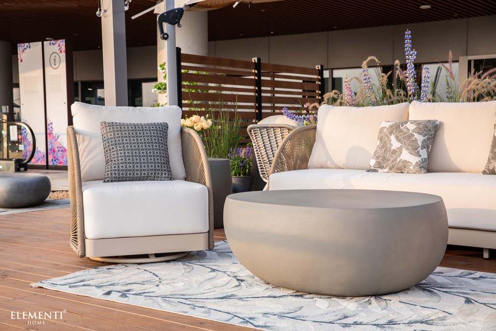 Single lounge chair from Malibu Collection by Elementi Outdoor Furnitures, paired with a round coffee table and soft cushions 