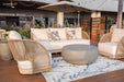 Full view of the Elementi Malibu Collection outdoor set with sofa, chairs, and coffee table on a deck with florals, perfect for stylish garden entertaining.