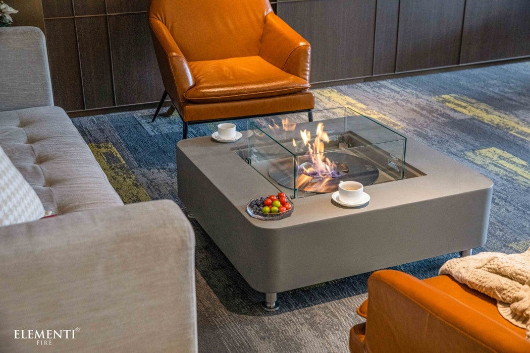 Lounge setup featuring the space grey Elementi Perth Fire Table with soft flames and cozy seating