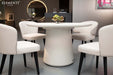 Elementi Rio Dining Table in cream white, styled in a modern room setting with four matching white chairs and a decorative centerpiece.