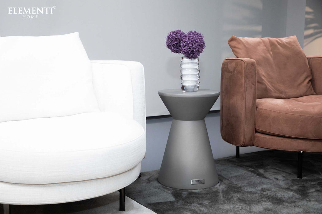 Elementi Rome Small Space Grey Side Table positioned between two sofas, decorated with a flower vase, illustrating its modern and versatile design in a living room setting.