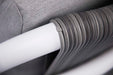 A detailed close-up of gray woven rope wrapping around a white frame, showcasing a design element of the Elementi Santorini Collection.
