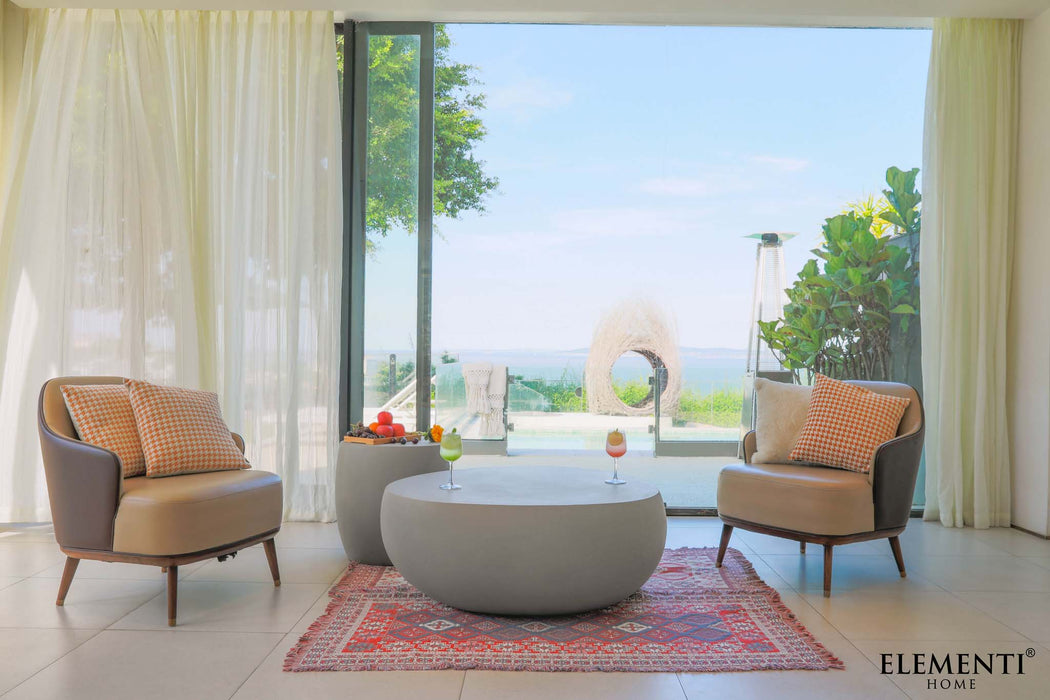 Elementi Space Grey Coffee Table in an outdoor setting, paired with armchairs, overlooking a garden view.