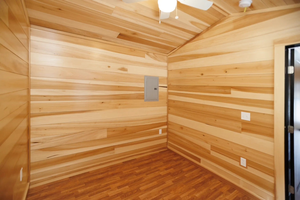 Empty room in the Oasis Tiny Estates Firestack Cabin showcasing the big and airy space with wood paneling.