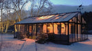 Exaco Janssens Gigant Greenhouse illuminated at night with snow surrounding the glass structure