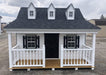 Exterior view of the Pennfield Cottage Playhouse by Little Cottage Company, showcasing a classic white and black paint scheme.