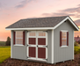 Ez-Fit Kits Heritage outdoor garden shed in gray with red doors and shutters on landscaped ground with pitched roof