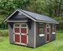 Outdoor garden shed with gray siding, red doors, and white-trimmed windows in a grassy backyard