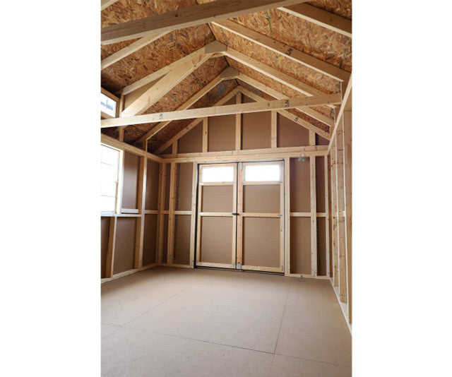 Spacious interior of Ez-Fit Skyview Shed Kit with exposed wood framing, high gable ceiling, double doors, and natural light windows.