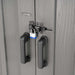 Close-up of Lifetime Farmhouse Storage Shed 60542 double door handles with black metal hasp latch secured by a blue padlock on wood-grain gray door surface