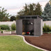 Lifetime 60542 Farmhouse Storage Shed with open double doors in a backyard garden at dusk, showing interior with lawn mower, garden tools, and built-in shelving
