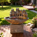 Four frog outdoor water fountain on pedestal bowl with gentle streams, set in landscaped backyard patio garden setting