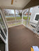 Front porch of the Champion Home No Loft by Oasis Tiny Estates, featuring wooden flooring and railings with a scenic view.