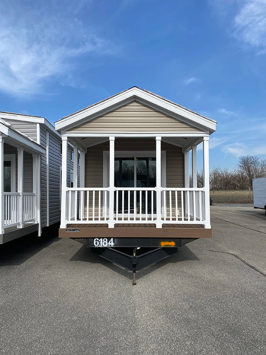 Front exterior view of the Champion Home without Loft by Oasis Tiny Estates, showing the porch and main entrance.