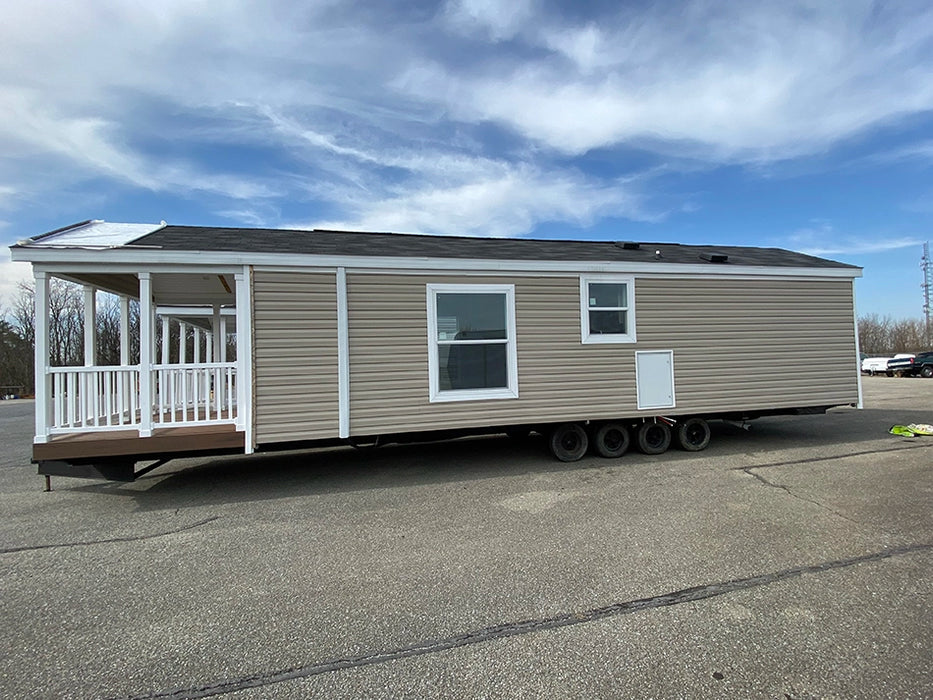 Full-length side view of the Champion Home no Loft by Oasis Tiny Estates, illustrating its compact design and mobility features.