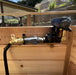 Fully assembled Outdoor Living Today (OLT) Auto-Watering Kit installed on a wooden panel.