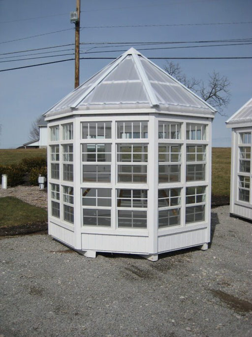 A Little Cottage Company Octagon Greenhouse fully assembled on a gravel.