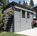 GardenSaver 12x4 cedar shed painted gray with black trim and sliding doors installed on modern backyard patio.