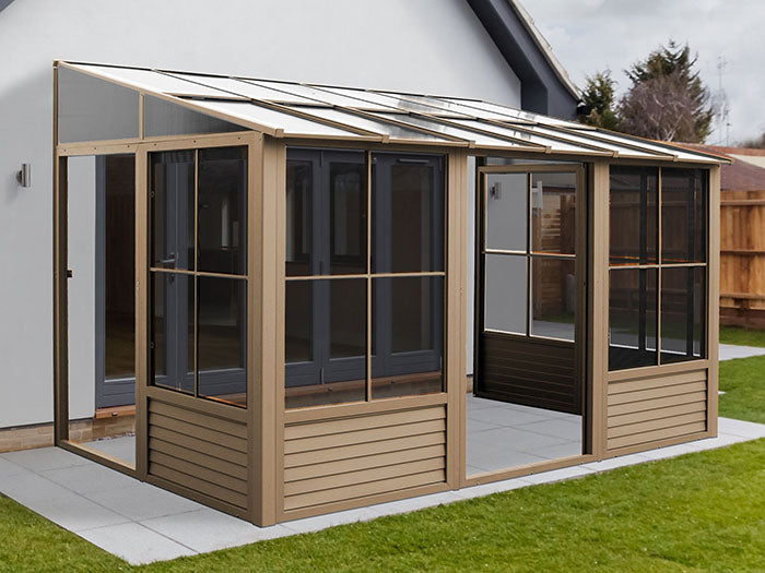 Full outdoor view of Gazebo Penguin Florence 8x12 wall-mounted solarium installed beside a house.