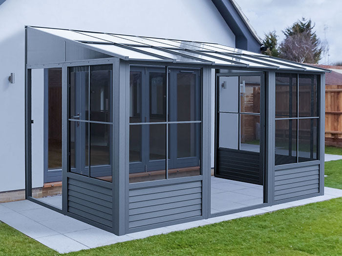 Full exterior view of Gazebo Penguin Florence wall-mounted add-a-room in slate, displaying its modern design and spacious interior beside a residential setting.