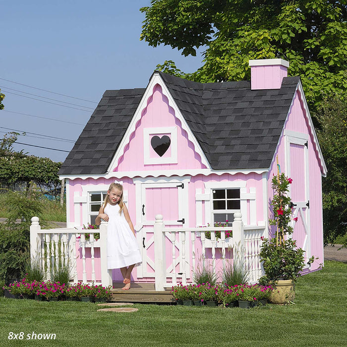 Girl playing outside the charming Victorian cottage playhouse in a garden setting.