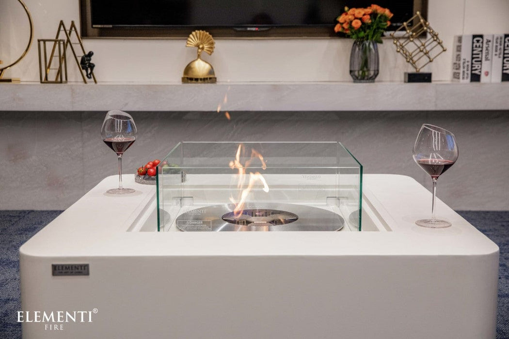Glass guard around the burning flame of the Elementi Perth Ethanol Fire Table with red wine and snacks